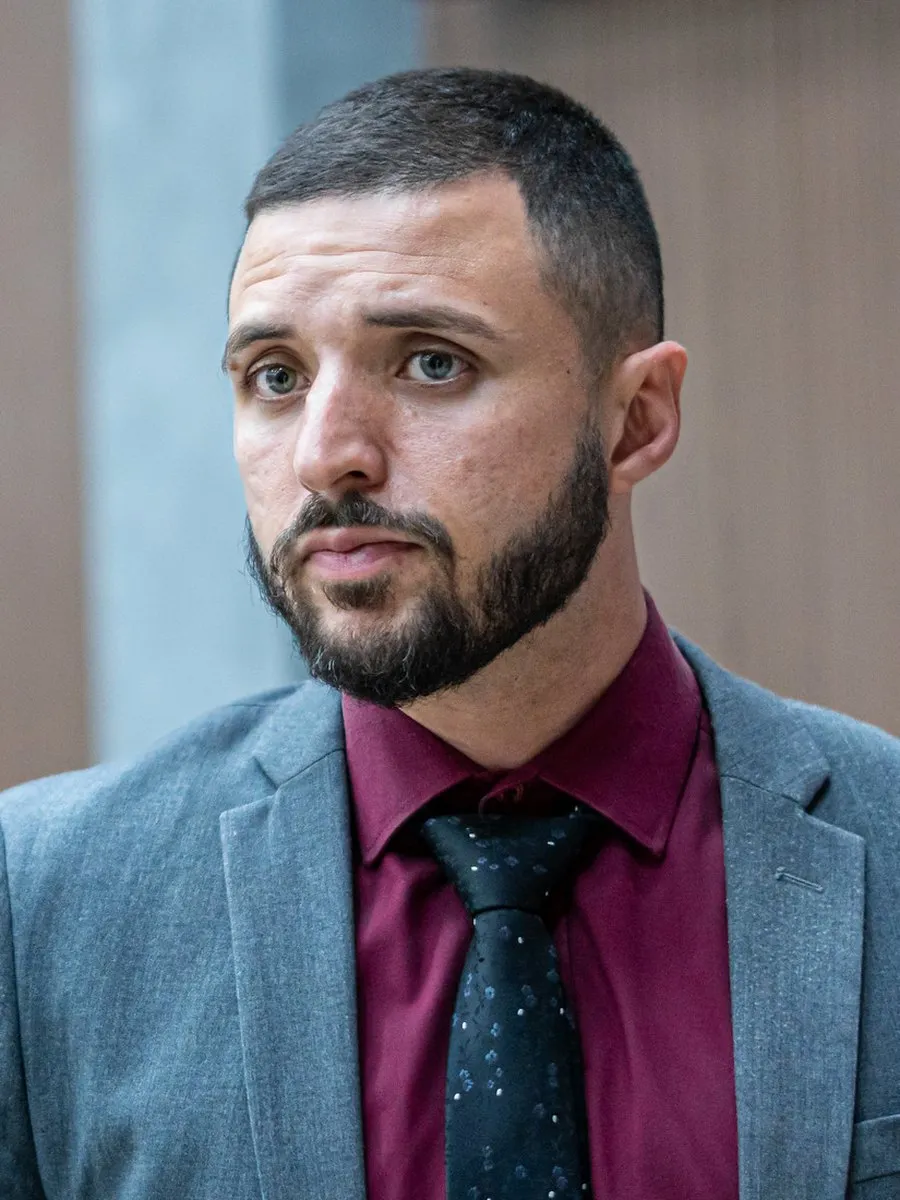 Dr. Nicolas Guimarães Novais Pinto Mendes, advogado, de terno cinza e camisa vinho